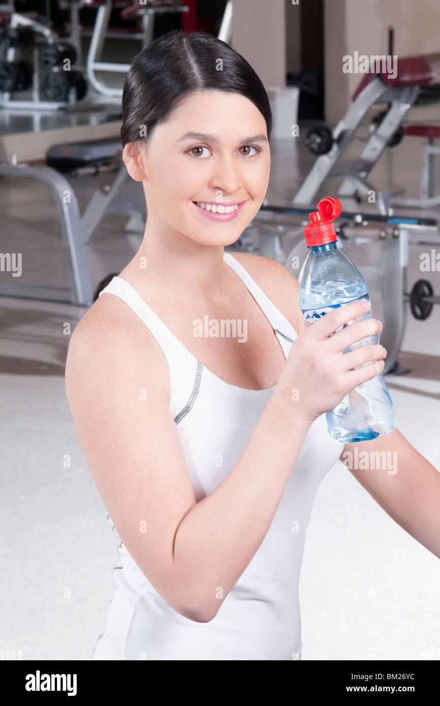 Portrait of a woman holding a water bottle in a gym Stock Photo