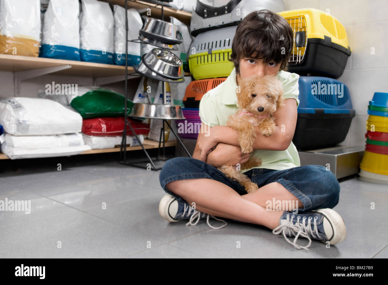 Boy carrying a puppy in a supermarket Stock Photo