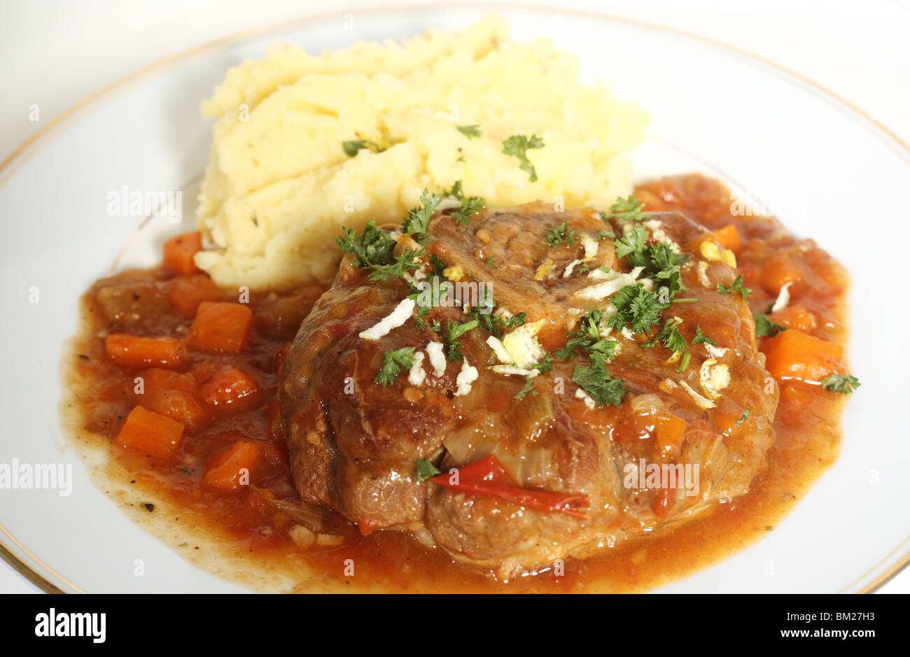 A plate with an ossobuco (braised veal shank steak) in the traditional