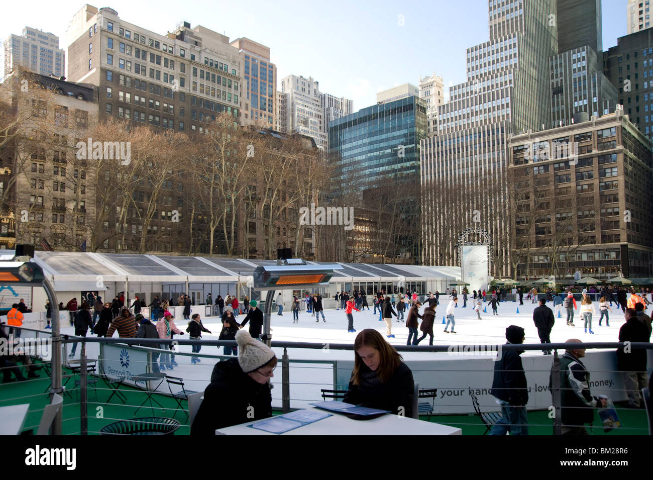 People sitting in a cafe next to the skating rink in Bryant Park, New York City, New York State, USA Stock Photo