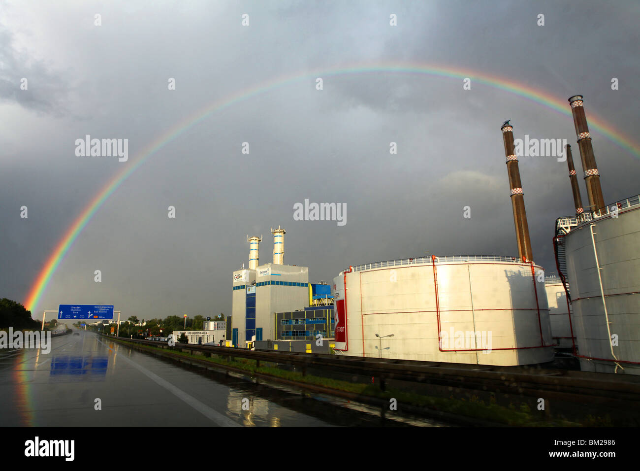 Gas tankers are lit up by a rainbow on the autobahn 4 in central Germany. Stock Photo