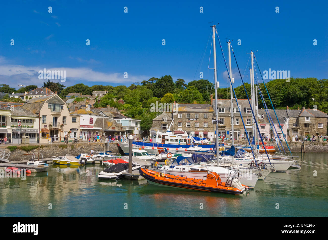 Busy tourist shops, small boats and yachts at high tide in Padstow