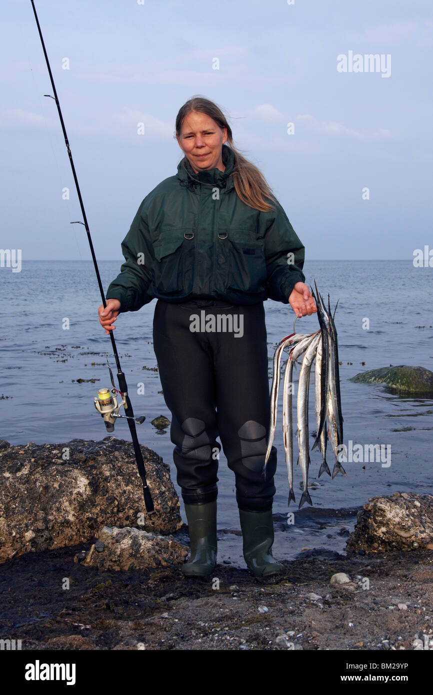 Female angler with caught Garfish (Belone belone), Germany Stock Photo
