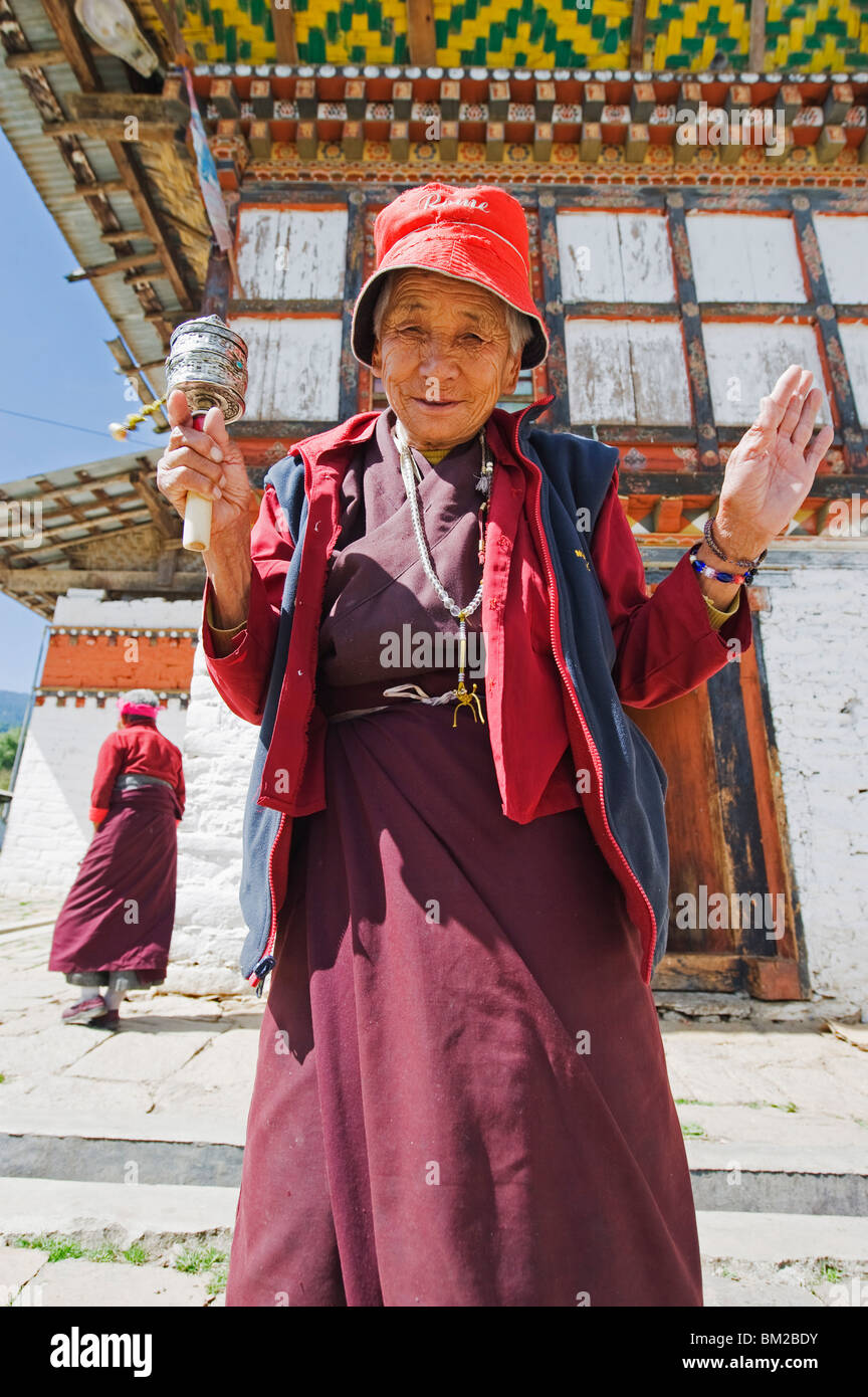 Woman spinning a prayer wheel, Jampay Lhakhang, built in 659 by Tibetan King Songtsen Gampo, Jakar, Bumthang, Bhutan Stock Photo