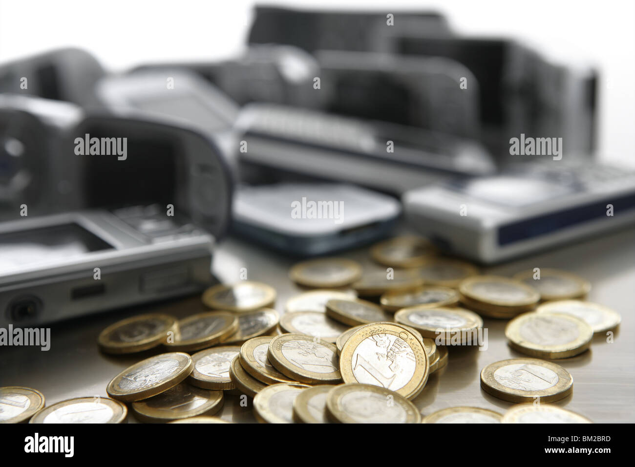 Assorted mixed mobile phones witt lots of euro coin in a studio still Stock Photo