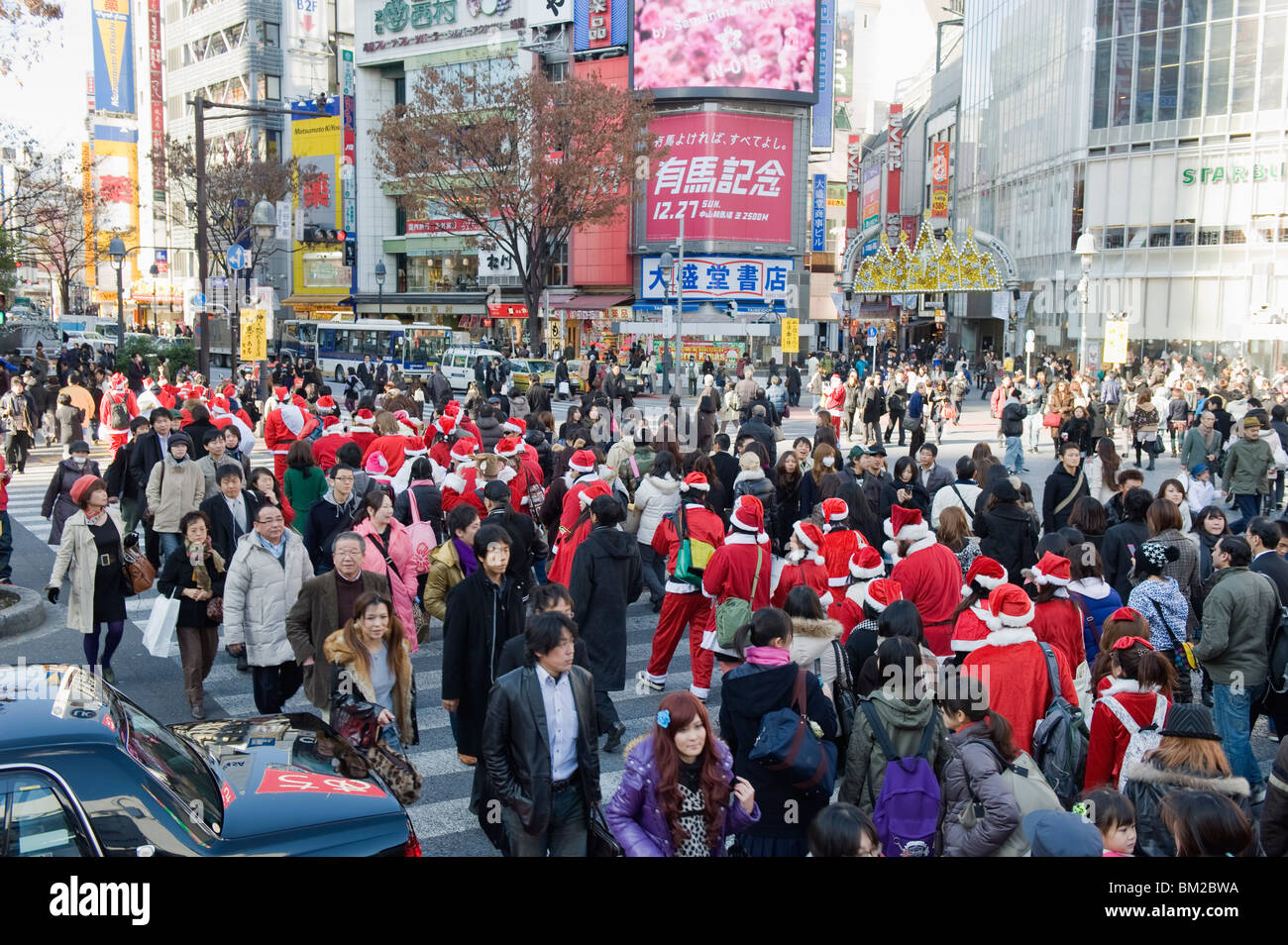 Christmas Santas walking across Shibuya crossing, Shibuya ward, Tokyo, Japan Stock Photo