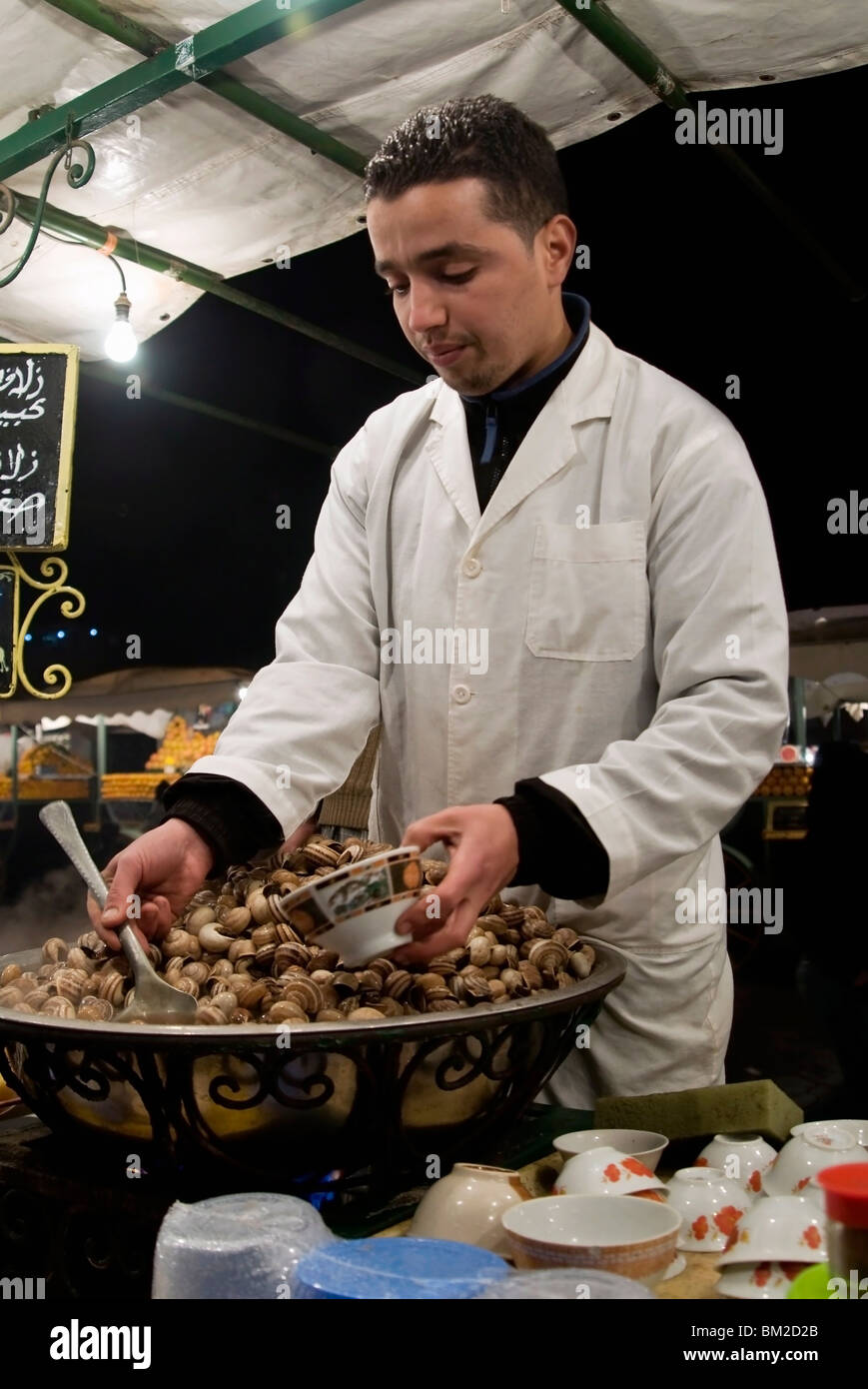 Cook serving snails from his stall in Djemaa el Fna, Place Jemaa el Fna (Djemaa el Fna), Marrakech (Marrakesh), Morocco Stock Photo