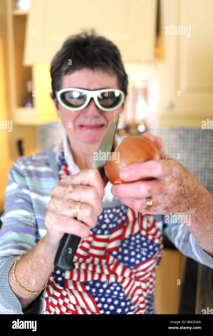 Woman preparing and peeling onions wearing special glasses to stop eyes