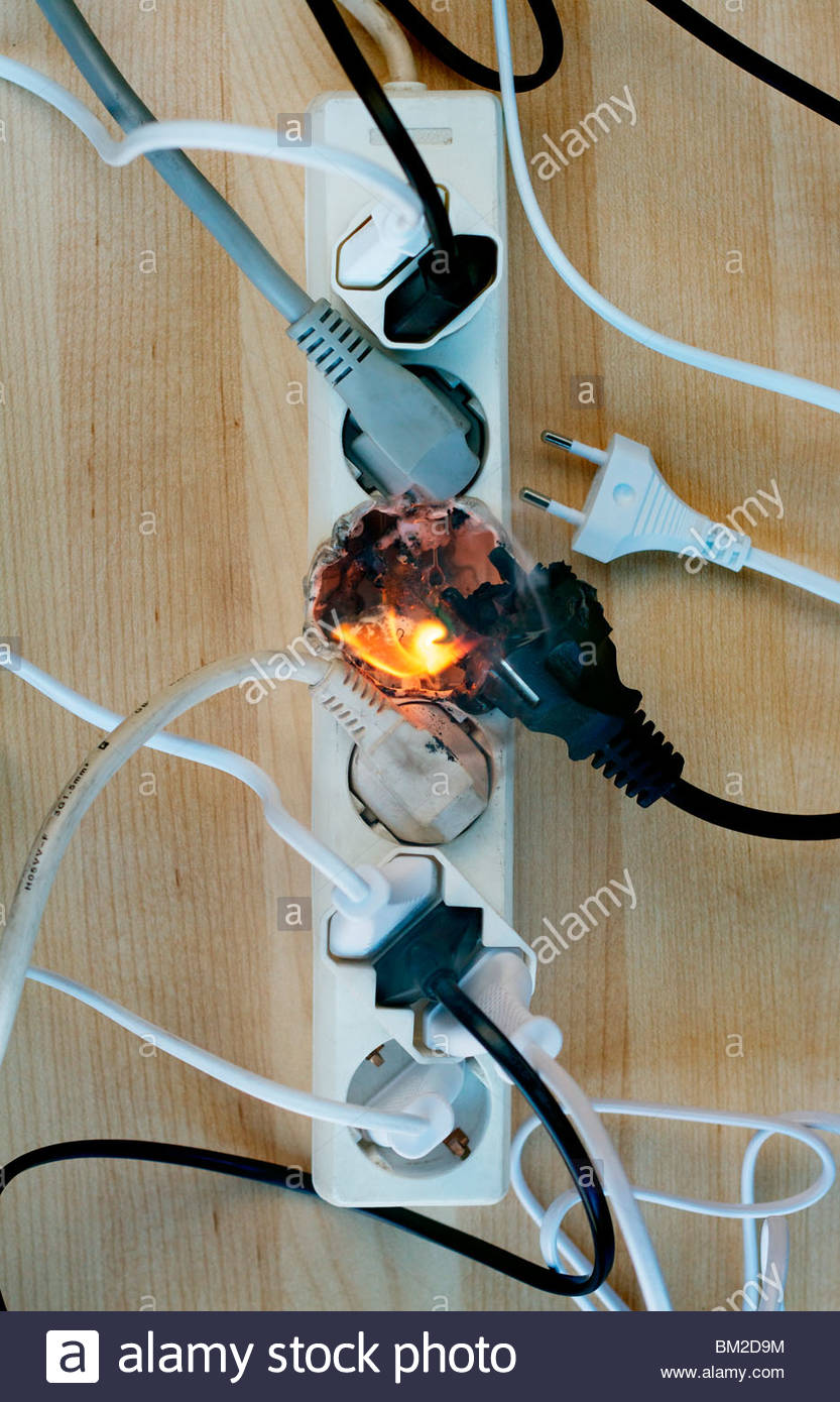Fire in overloaded power strip. European style connectors Stock Photo