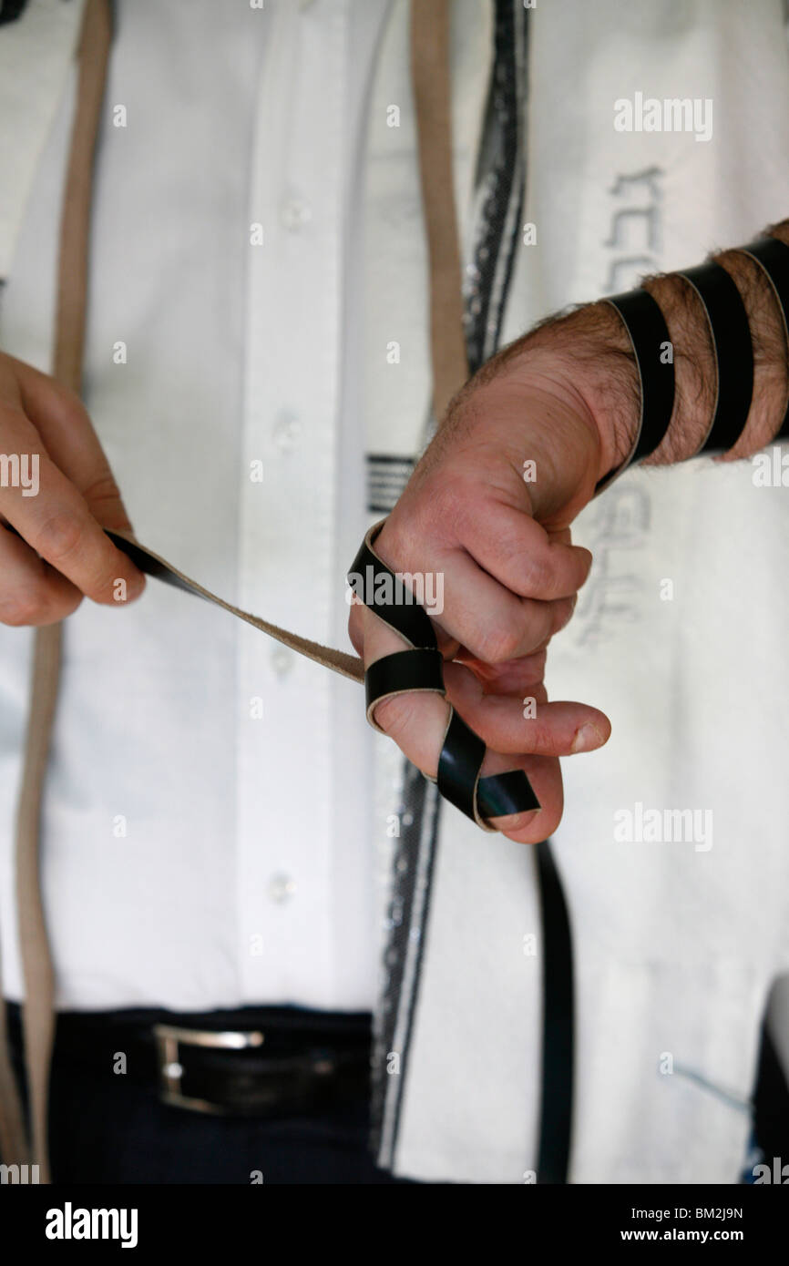 Rabbi putting on phylacteries, Paris, France Stock Photo