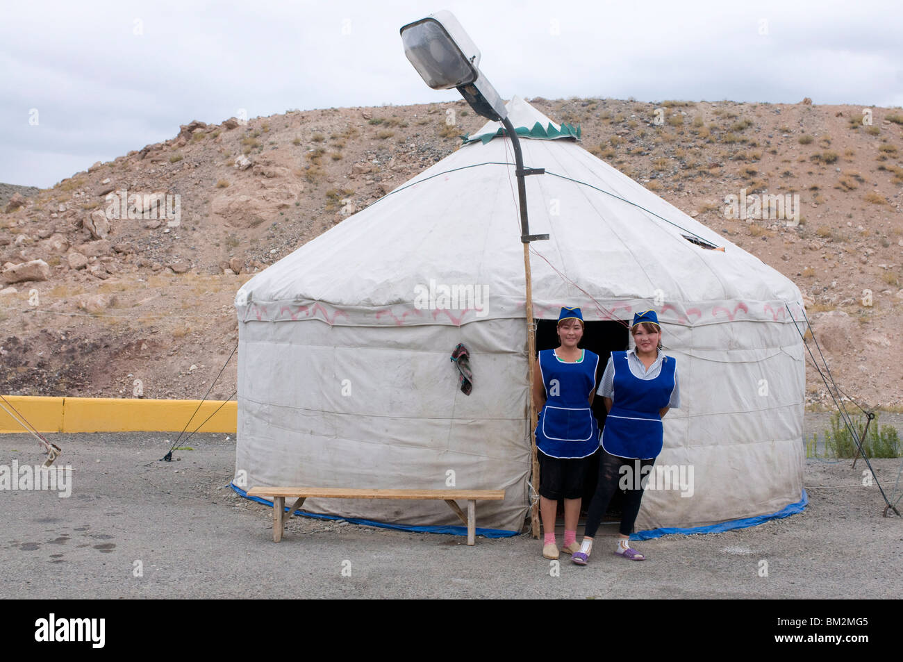 Women in front of a traditional yurt acting as a restaurant with a street lamp waiting for customers, Charyn Canyon, Kazakhstan Stock Photo