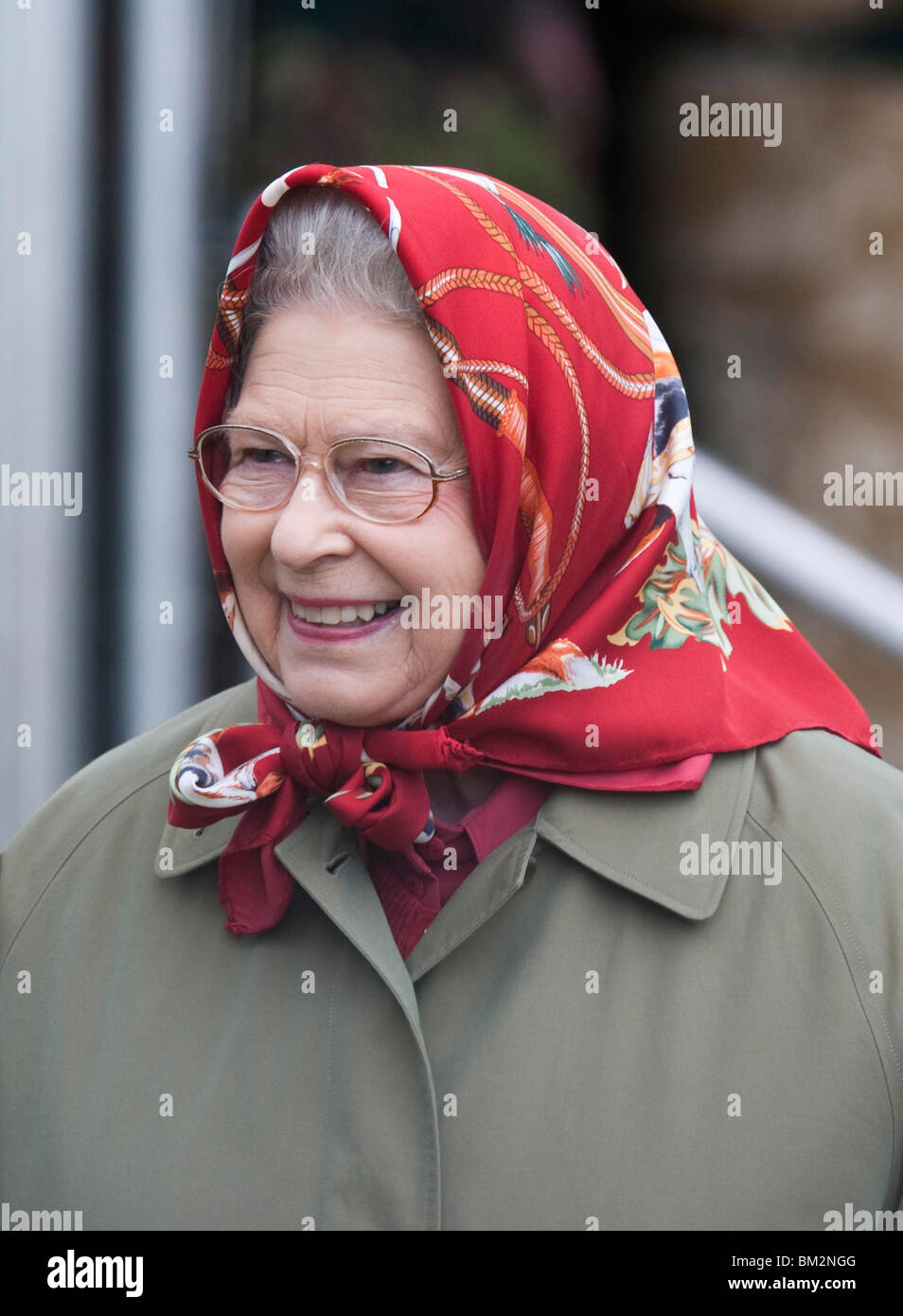 Britain's Queen Elizabeth II wearing a raincoat and red scarf at the