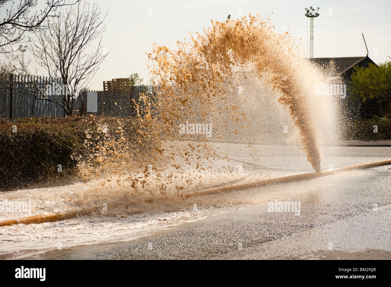 High Volume fire hose burst with water pouring out of leak Stock Photo