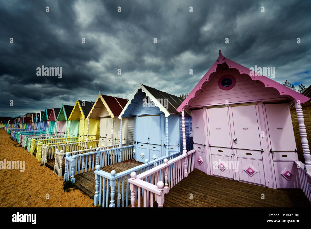 colourful seaside beach huts and shelters at Mersea Island Essex UK Stock Photo