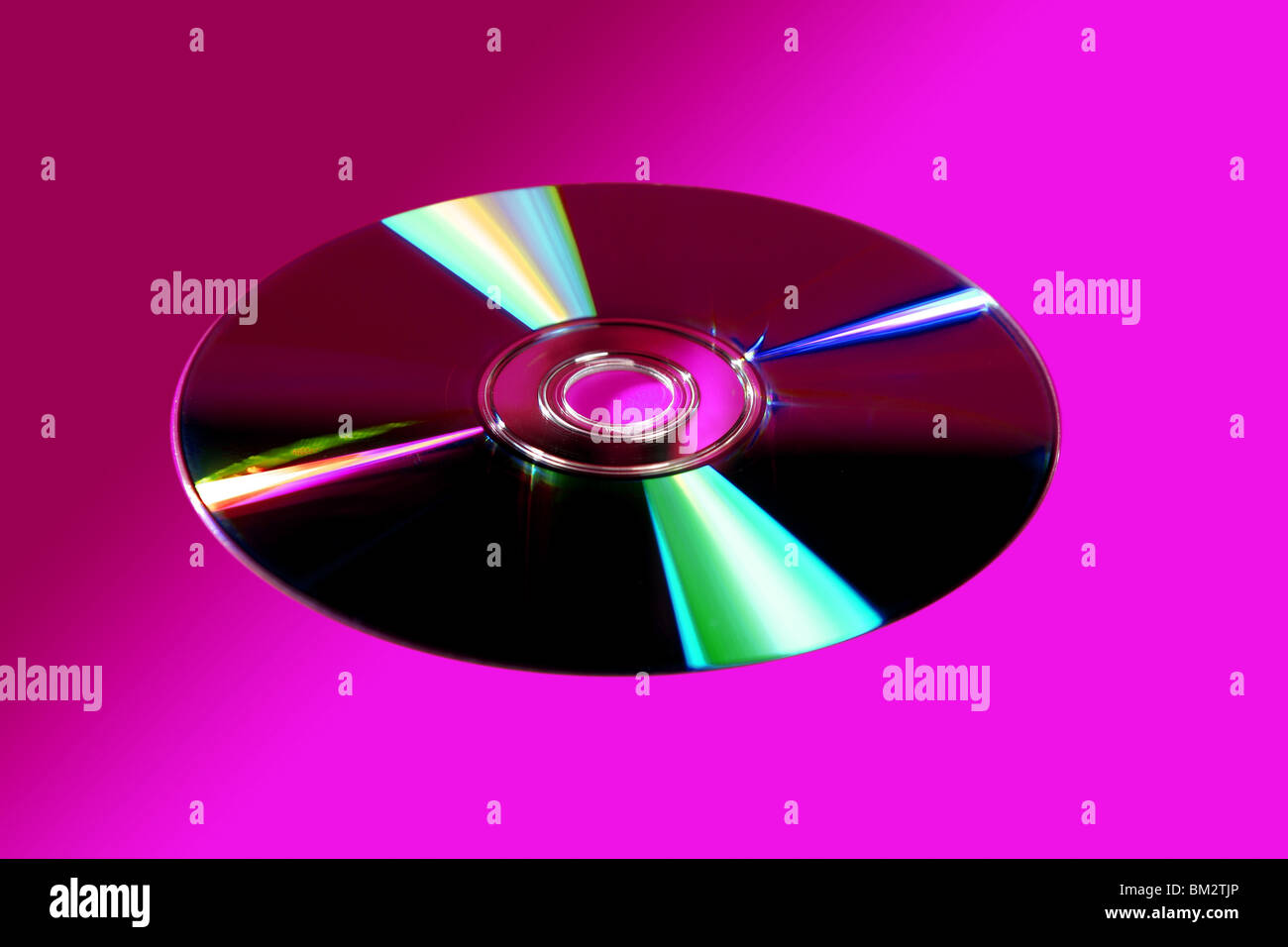 CD DVD disk with colorful reflexion over vivid pink background Stock Photo