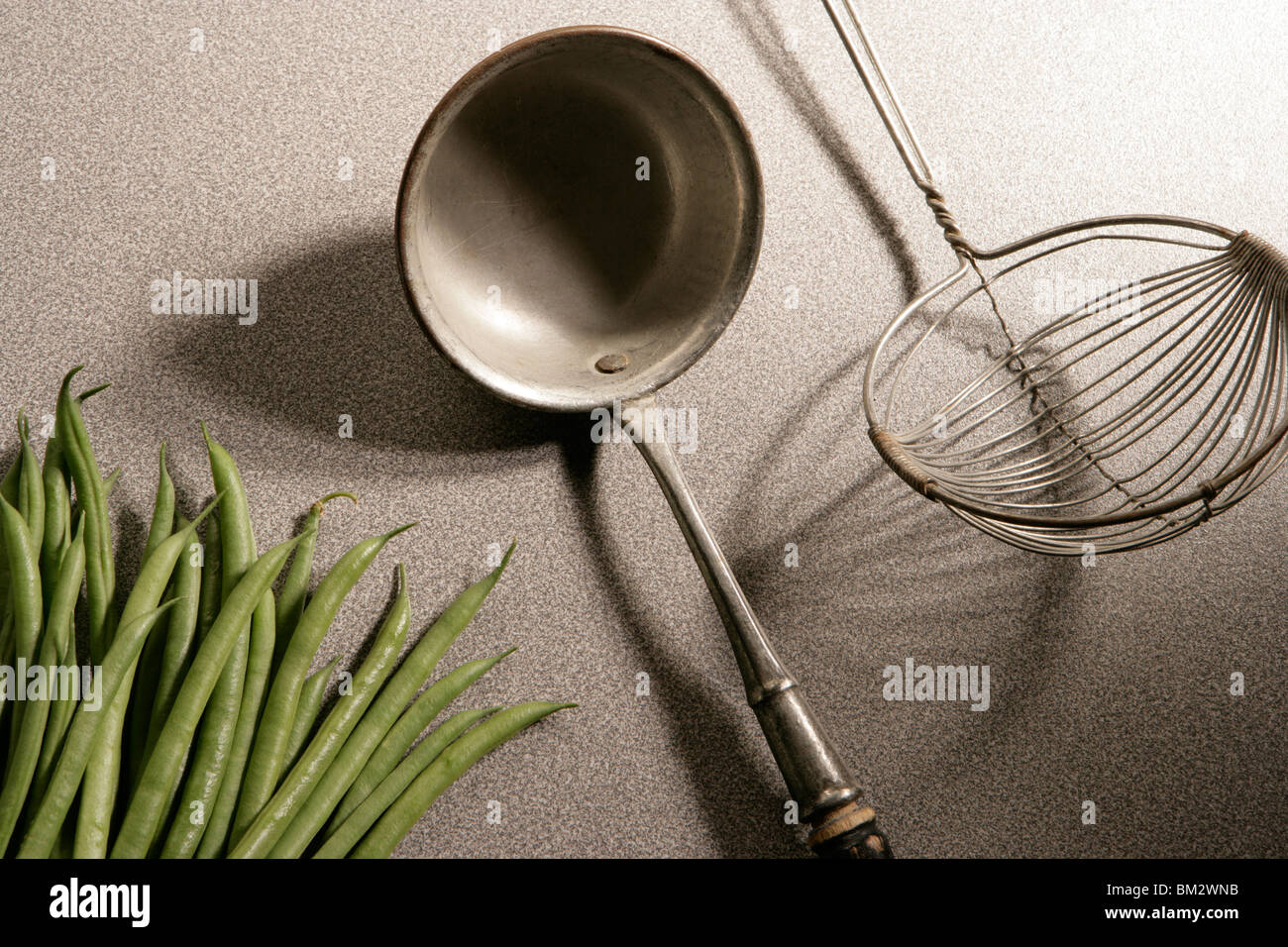 Old kitchen utensils with fresh green beans Stock Photo