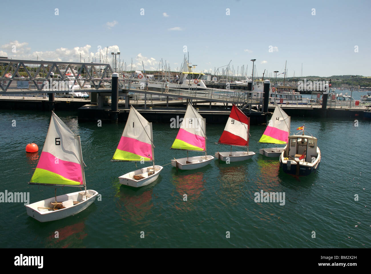 Colourful numbered sailing dinghies in a row, Barbican pontoon