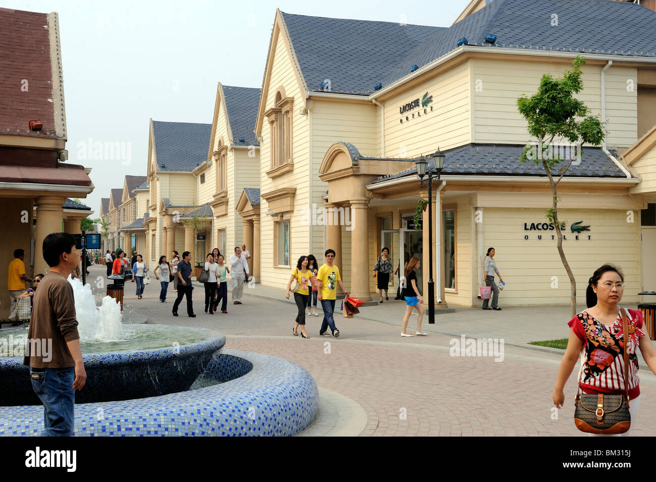 Chinese consumers walk at Beijing Scitech Premium Outlet Mall in