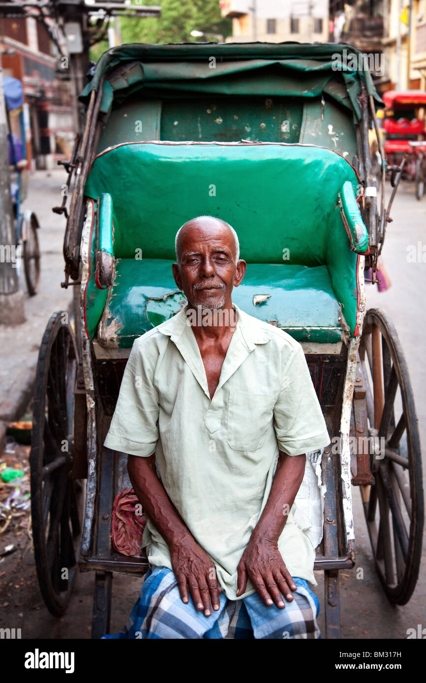 A rickshaw wallah with his buggy resting on the streets of Kolkata , India street scenes. Stock Photo