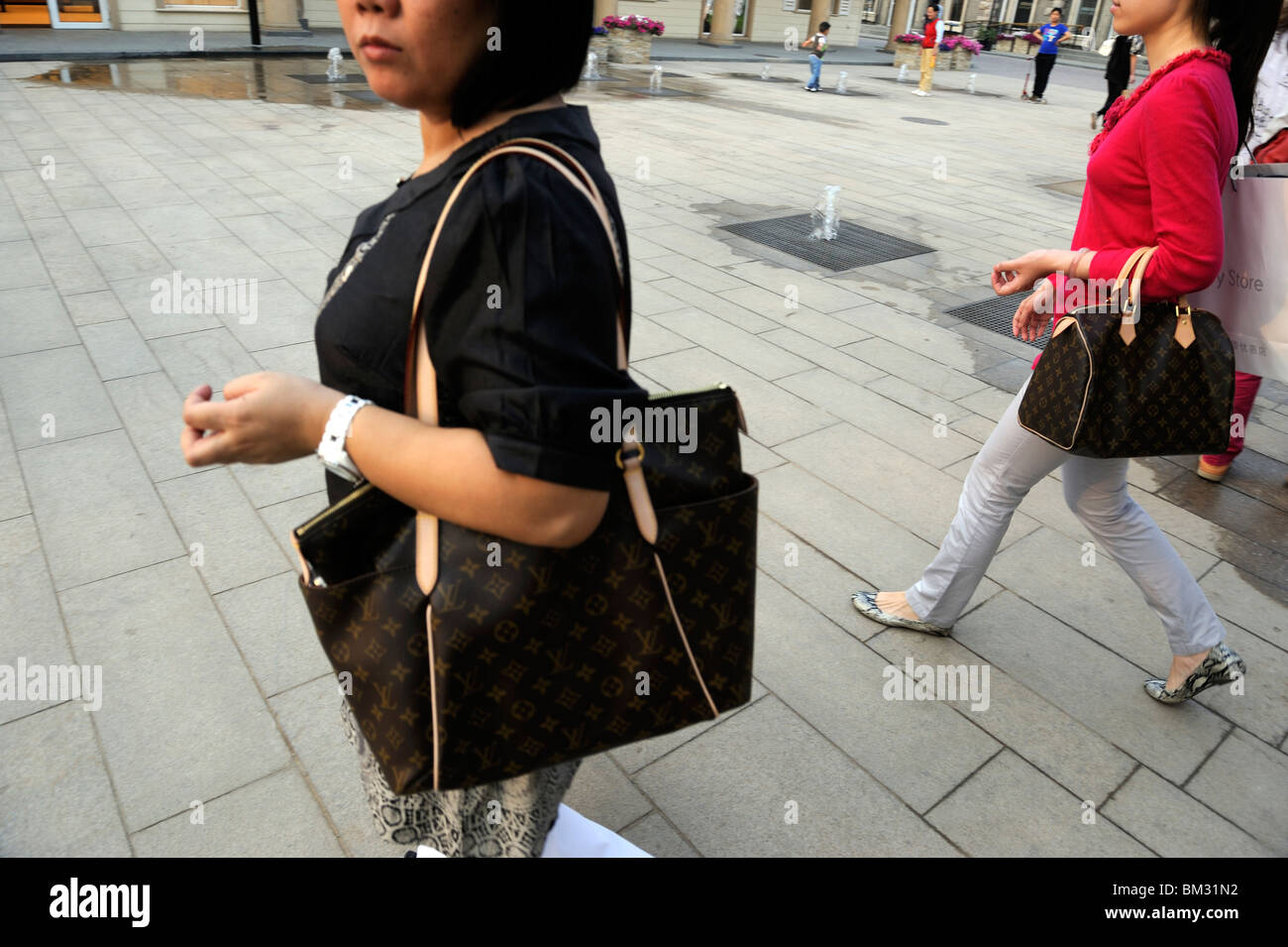 Two Chinese ladies carry Louis Vuitton handbags at Beijing Scitech Premium  Outlet Mall in Beijing, China. 15-May-2010 Stock Photo - Alamy