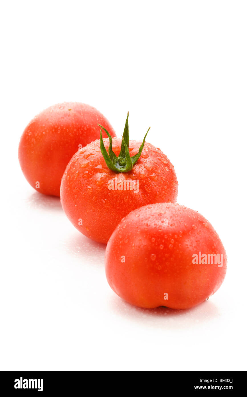 Three tomatoes on white background Stock Photo - Alamy
