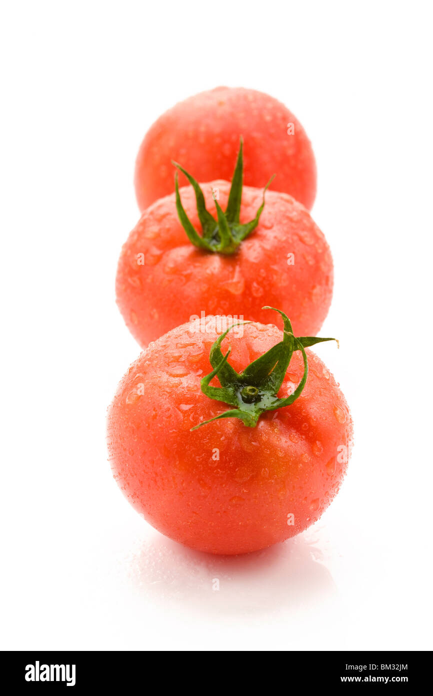 Three tomatoes on white background Stock Photo - Alamy