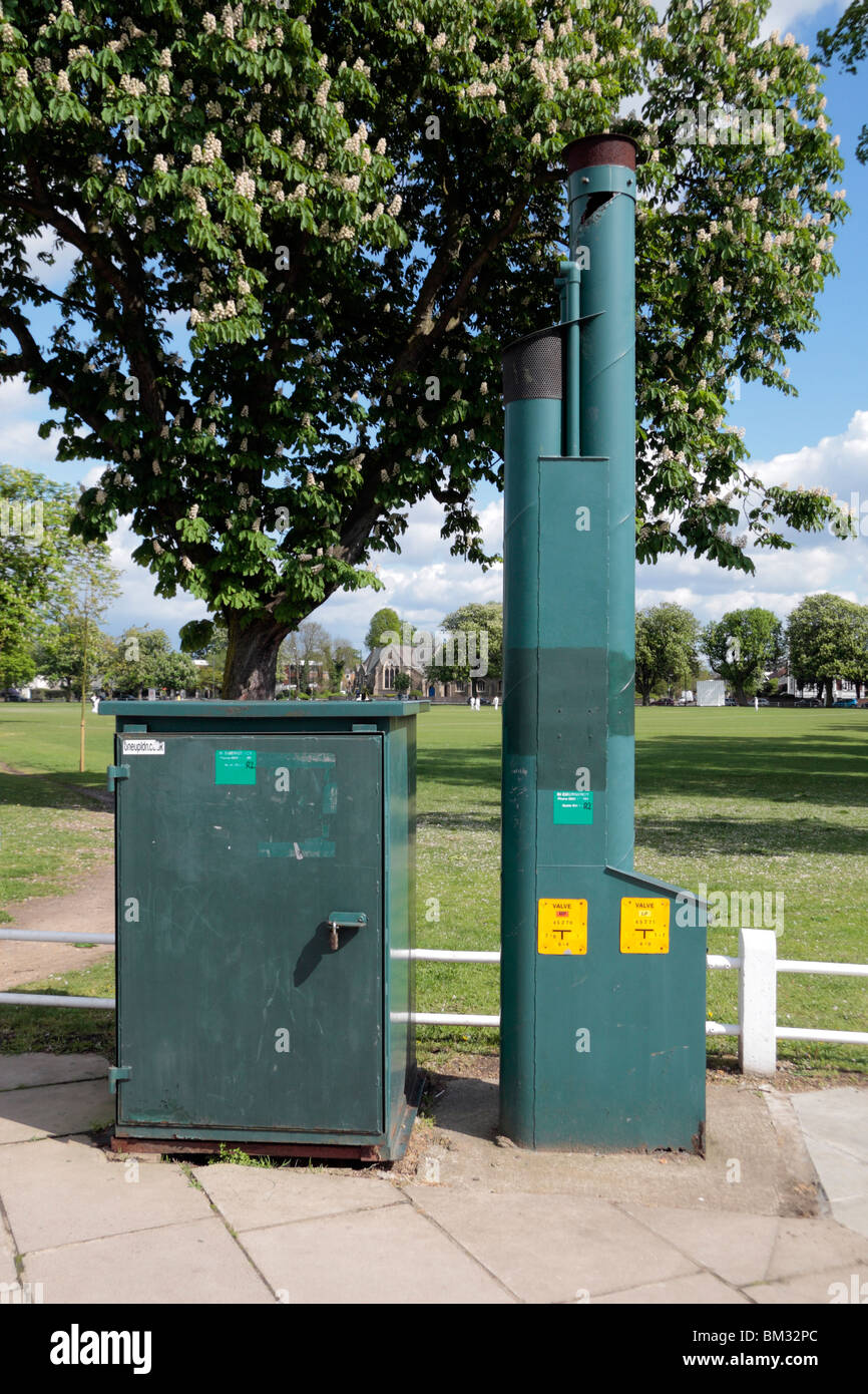 A gas safety chimney and electrical green box beside Twickenham Green, UK Stock Photo