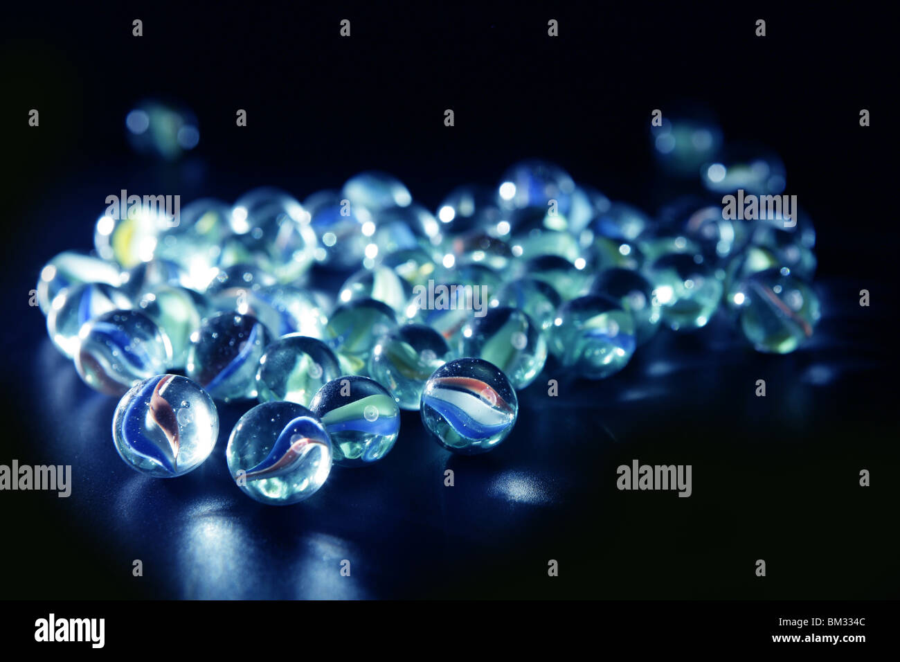 glass marbles with blue reflections over black background Stock Photo