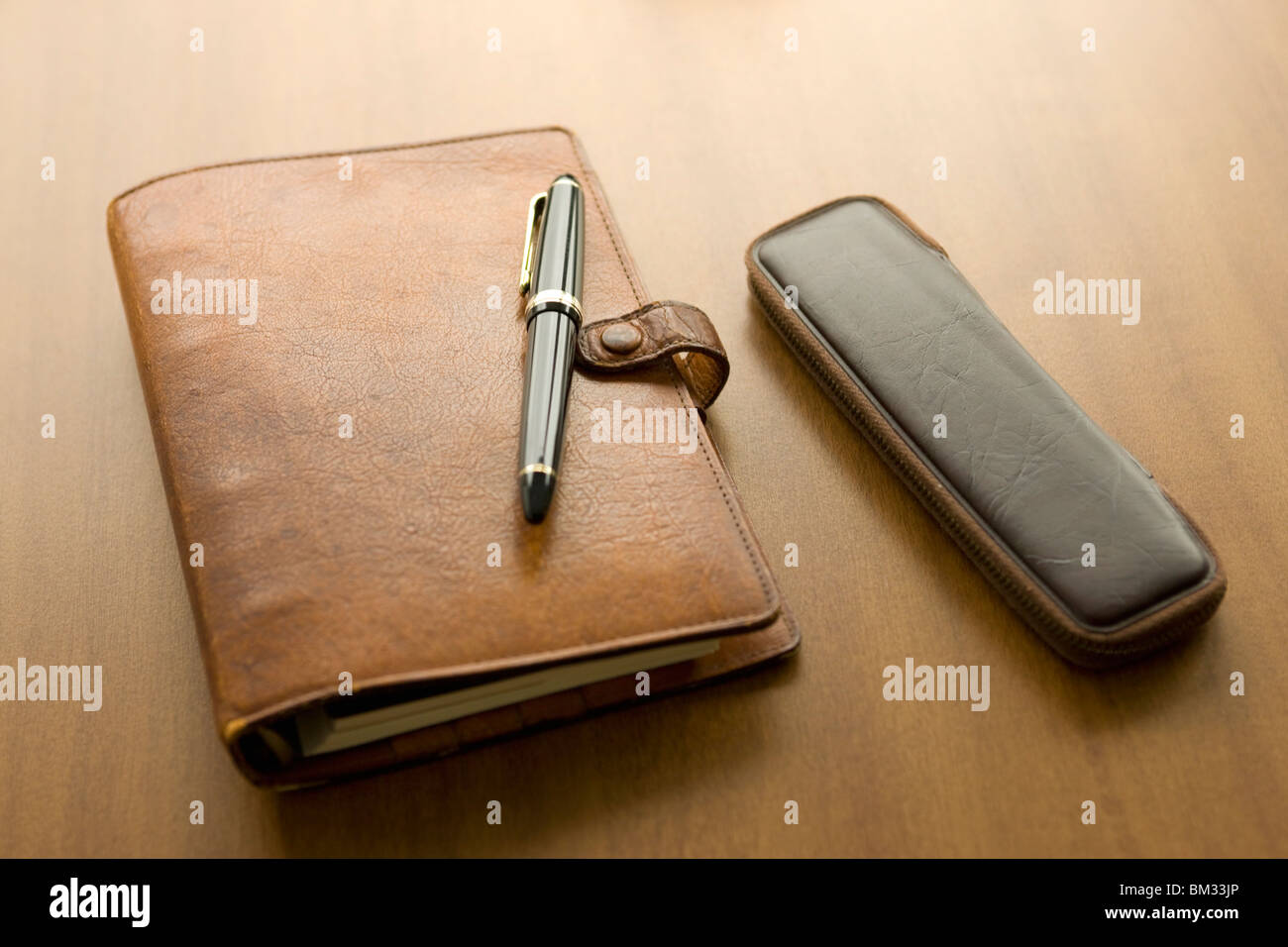 Diary, ink pen and pencil case on a desk Stock Photo
