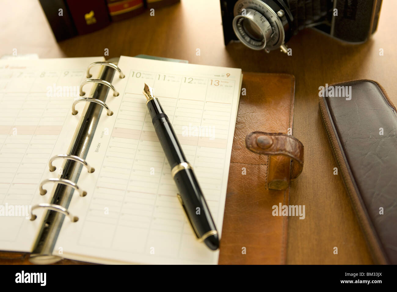 Diary, ink pen, pencil case and camera on a desk Stock Photo