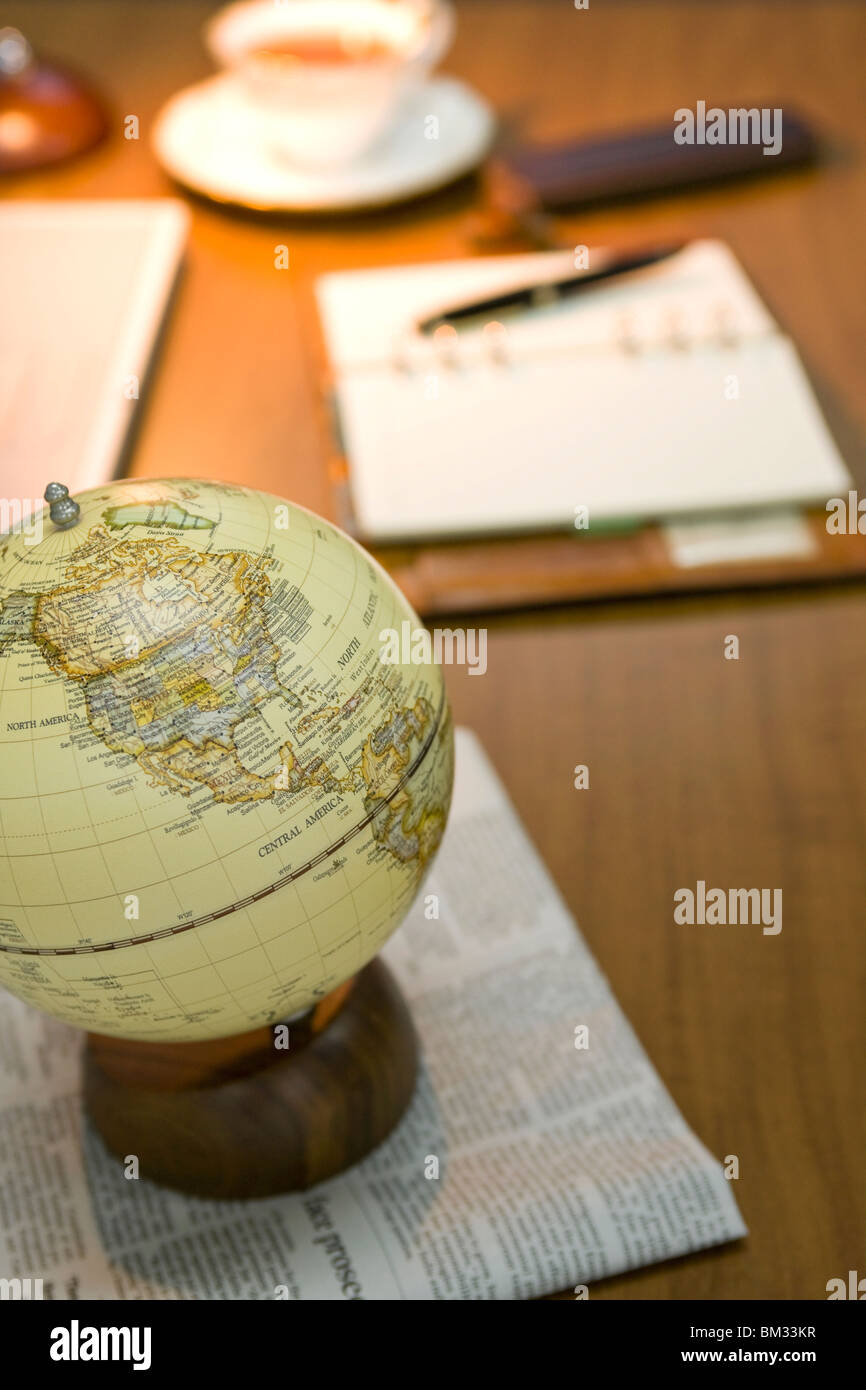 Globe and newspaper on a desk Stock Photo
