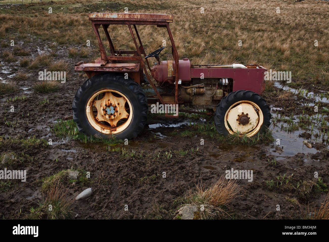 Abandoned tractor in a muddy field Stock Photo Alamy