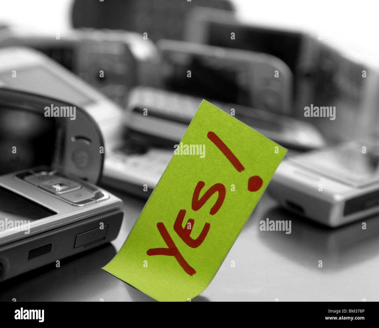 Assorted mobile phones and written word: YES. Message at the office Stock Photo