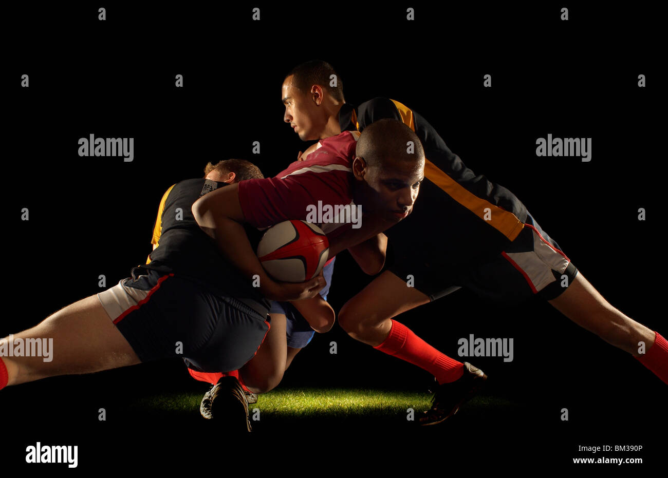 Rugby player tackled by two opponents Stock Photo