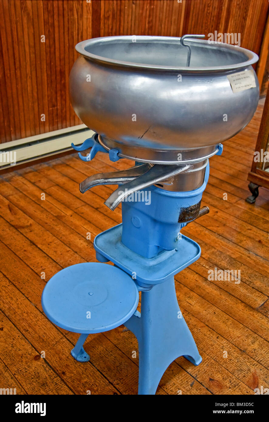 This vertical image is of a blue antique cream separator, sometimes