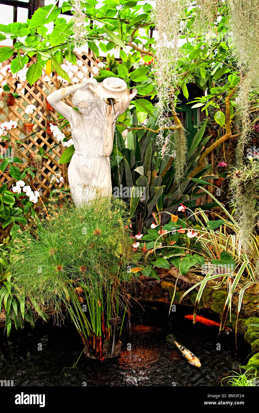 Statue Of Woman Pouring Water From Vase Into Aquatic Water Garden