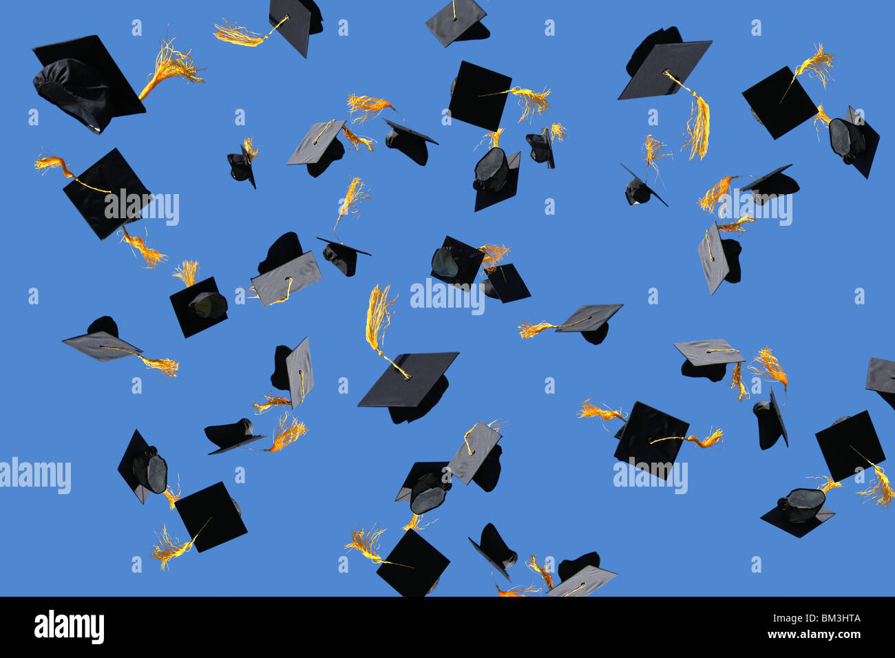 Graduation caps thrown into air Stock Photo