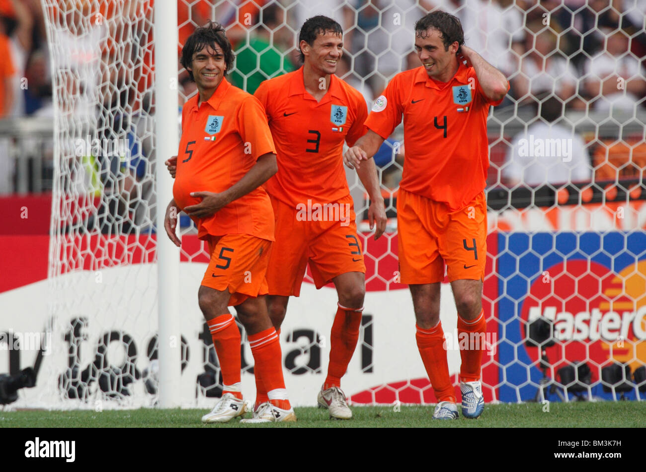 Giovanni Van Bronckhorst (5) hides the ball under his shirt as he celebrates a victory over Cote d'ivoire at the 2006 World Cup. Stock Photo