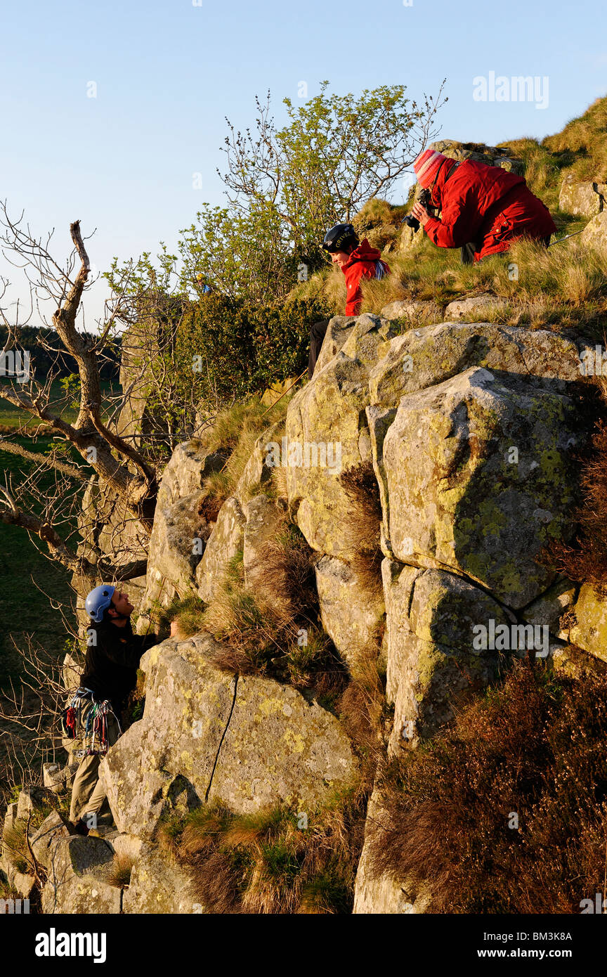 Rock climbers photographed at the top of a route on Peel Crag in Northumberland Stock Photo