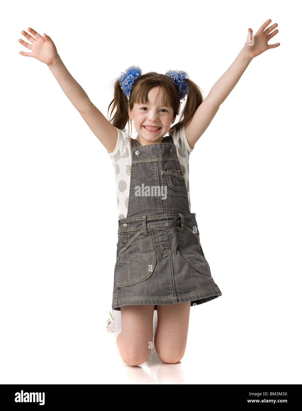 little girl stands on knees and holds hands up, isolated on white Stock ...