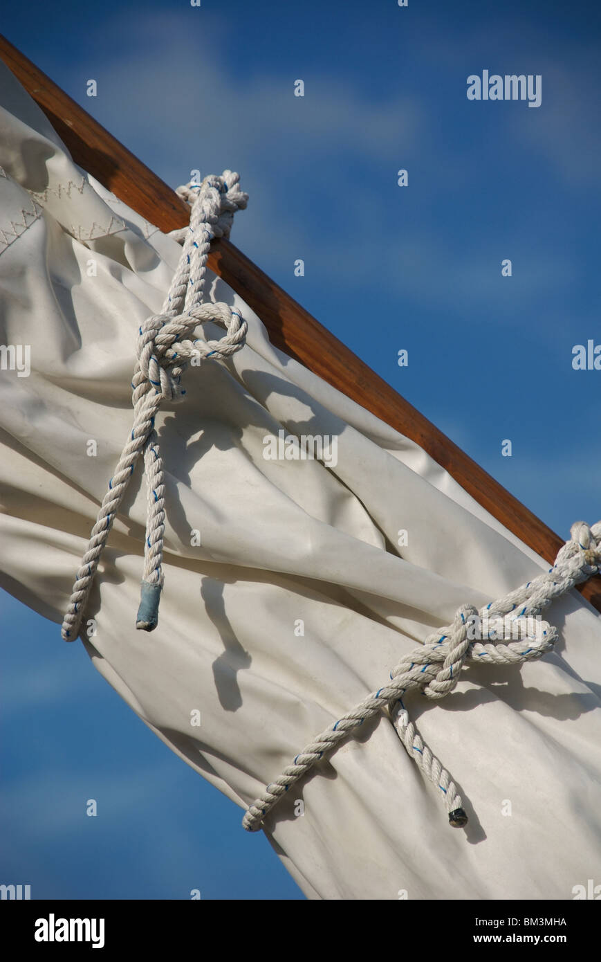 Detail of white canvas sail, ships rigging and rope knots, Falmouth