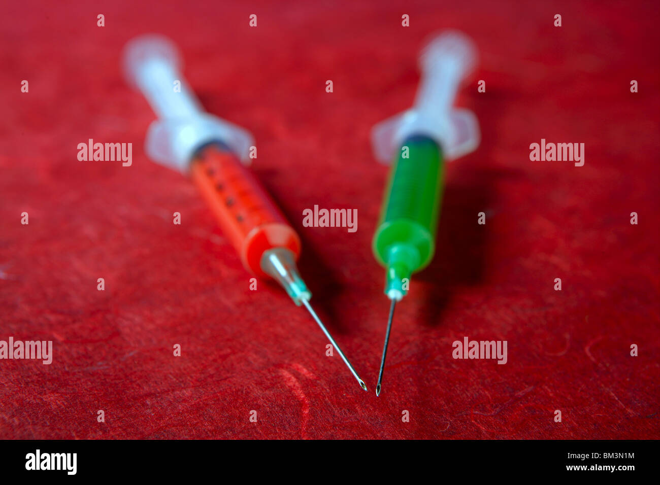 Two red and green syringe, health, addiction, medical research metaphor Stock Photo
