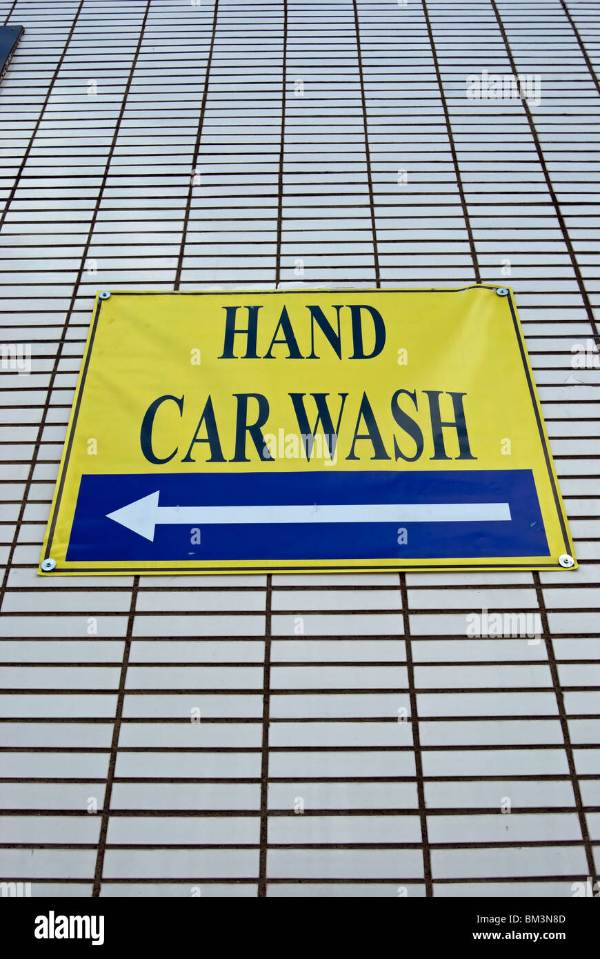 hand-car-wash-sign-with-left-pointing-arrow-on-an-office-building-stock