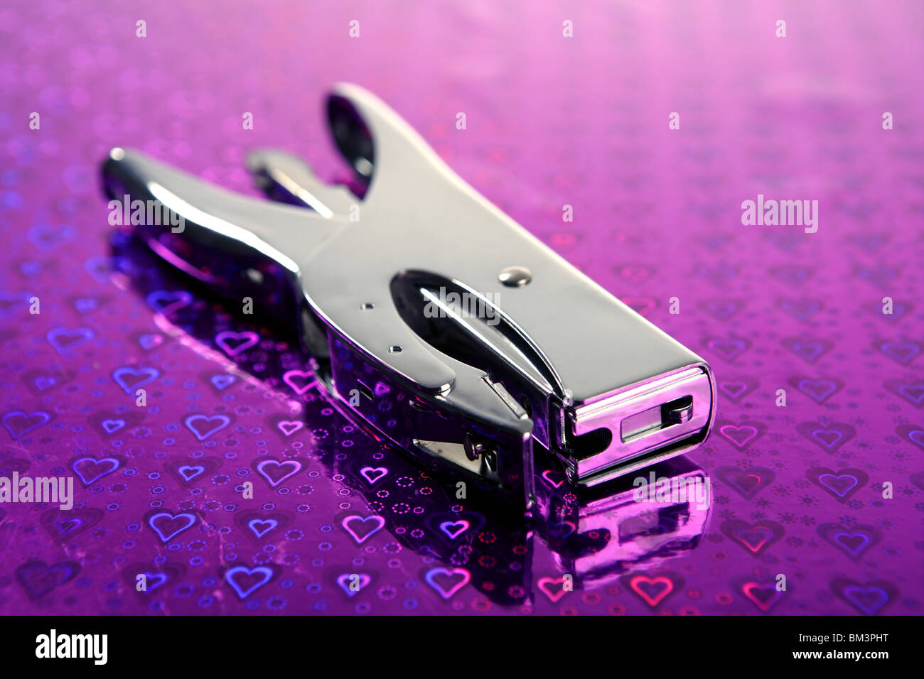 professional office stuff, chrome stapler over purple heart background ...