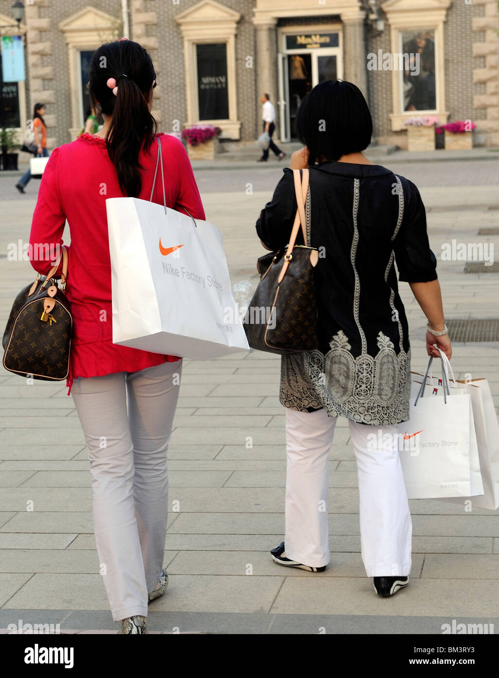 Two Chinese ladies carry Nike shopping bags at Beijing Scitech Premium  Outlet Mall in Beijing, China. 15-May-2010 Stock Photo - Alamy