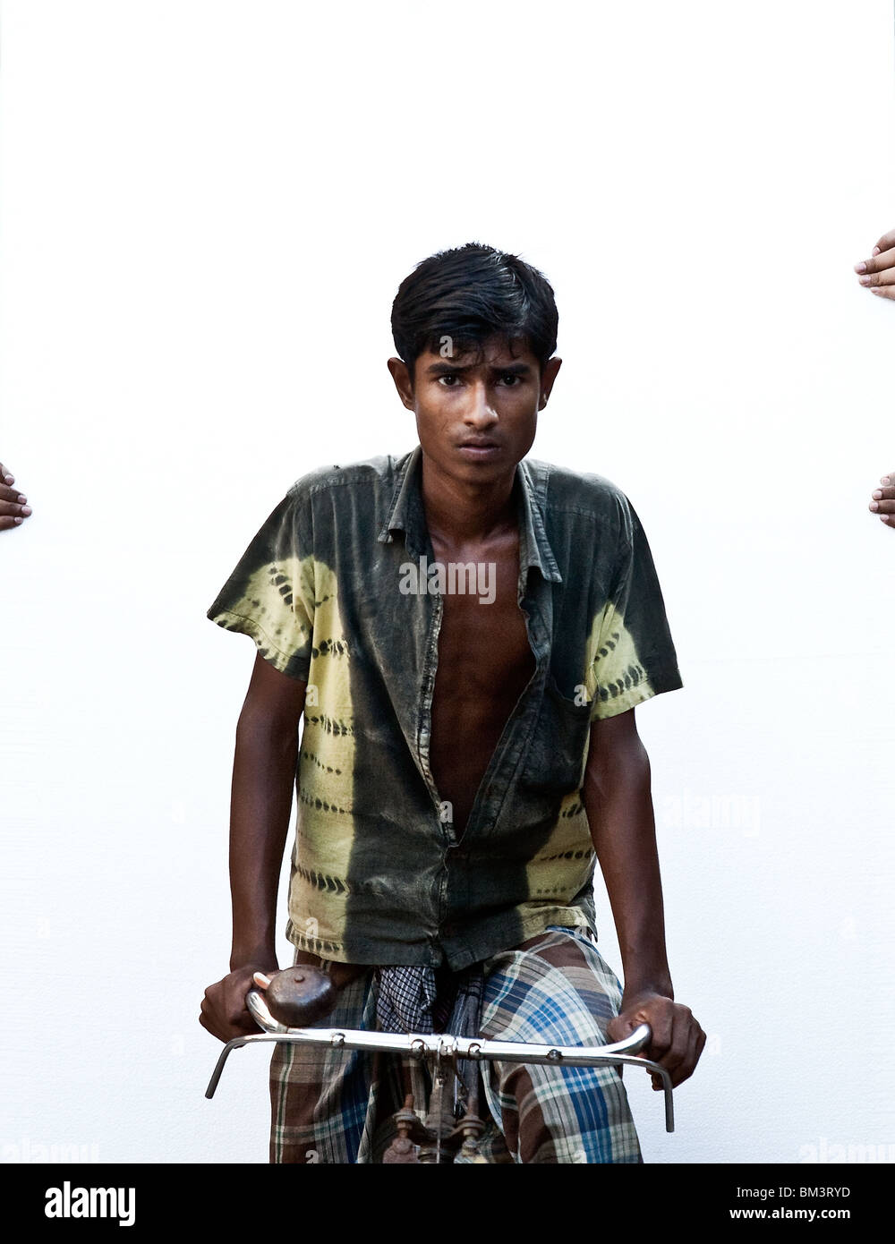 A bicycle courier carry's  gyprock with the help of two colleagues on the back of his bike in Dhaka, Bangladesh Stock Photo
