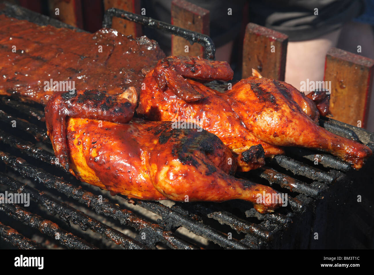 chicken being barbecued on grille Stock Photo