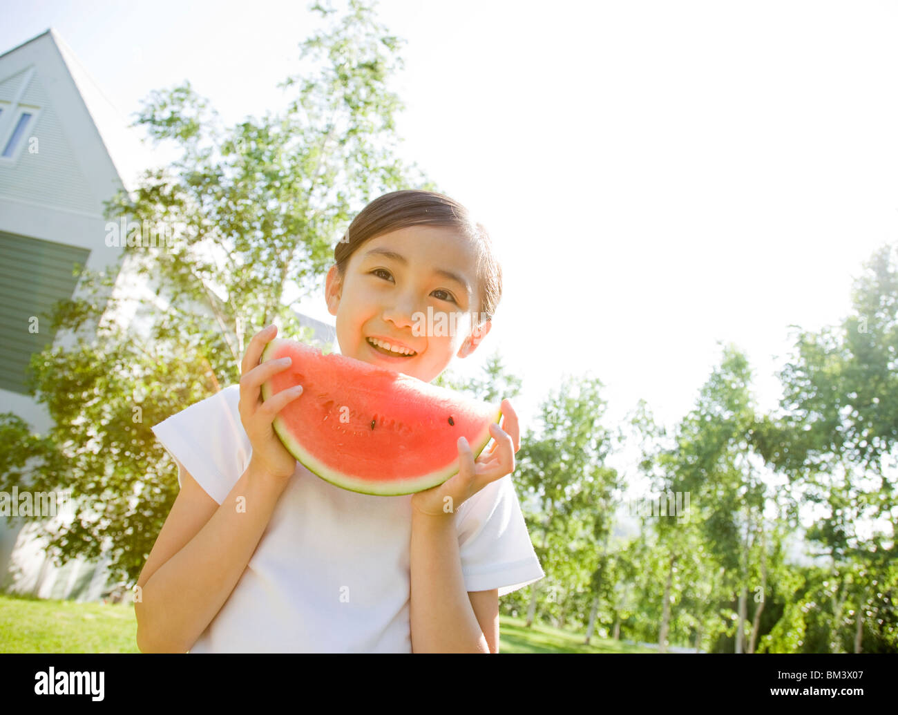 Smiling Girl Holding a Slice of Watermelon Stock Photo
