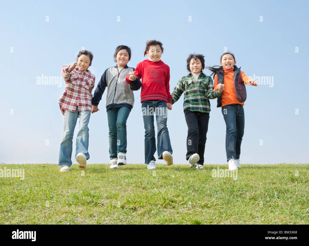 Boys and Girls Holding Hands, Walking Down Together Stock Photo