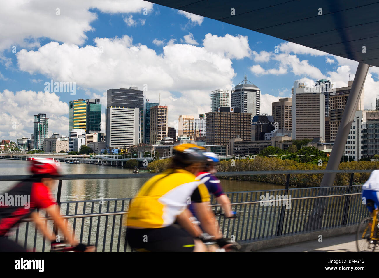 Cyclists on the Goodwill Bridge with the city skyline in the background. South Bank, Brisbane, Queensland, Australia Stock Photo